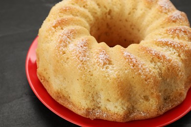 Photo of Delicious freshly baked sponge cake on black table, closeup