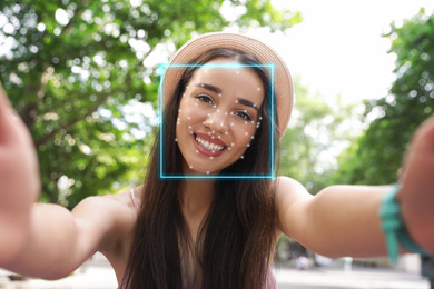 Facial recognition system. Woman with scanner frame and digital biometric grid, outdoors