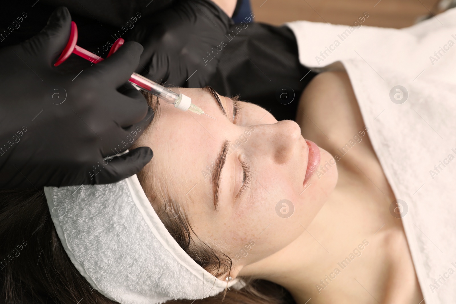 Photo of Cosmetologist giving facial injection to patient, closeup. Cosmetic surgery