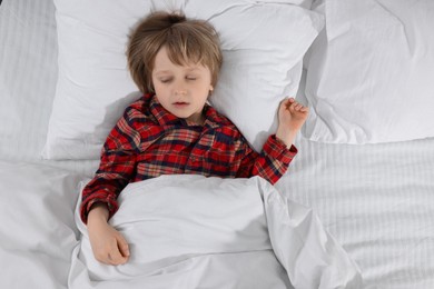 Little boy snoring while sleeping in bed, top view