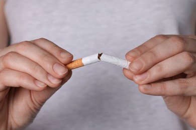 Stop smoking concept. Woman breaking cigarette, closeup