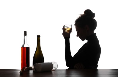 Photo of Alcohol addiction. Woman with glass and bottles on white background