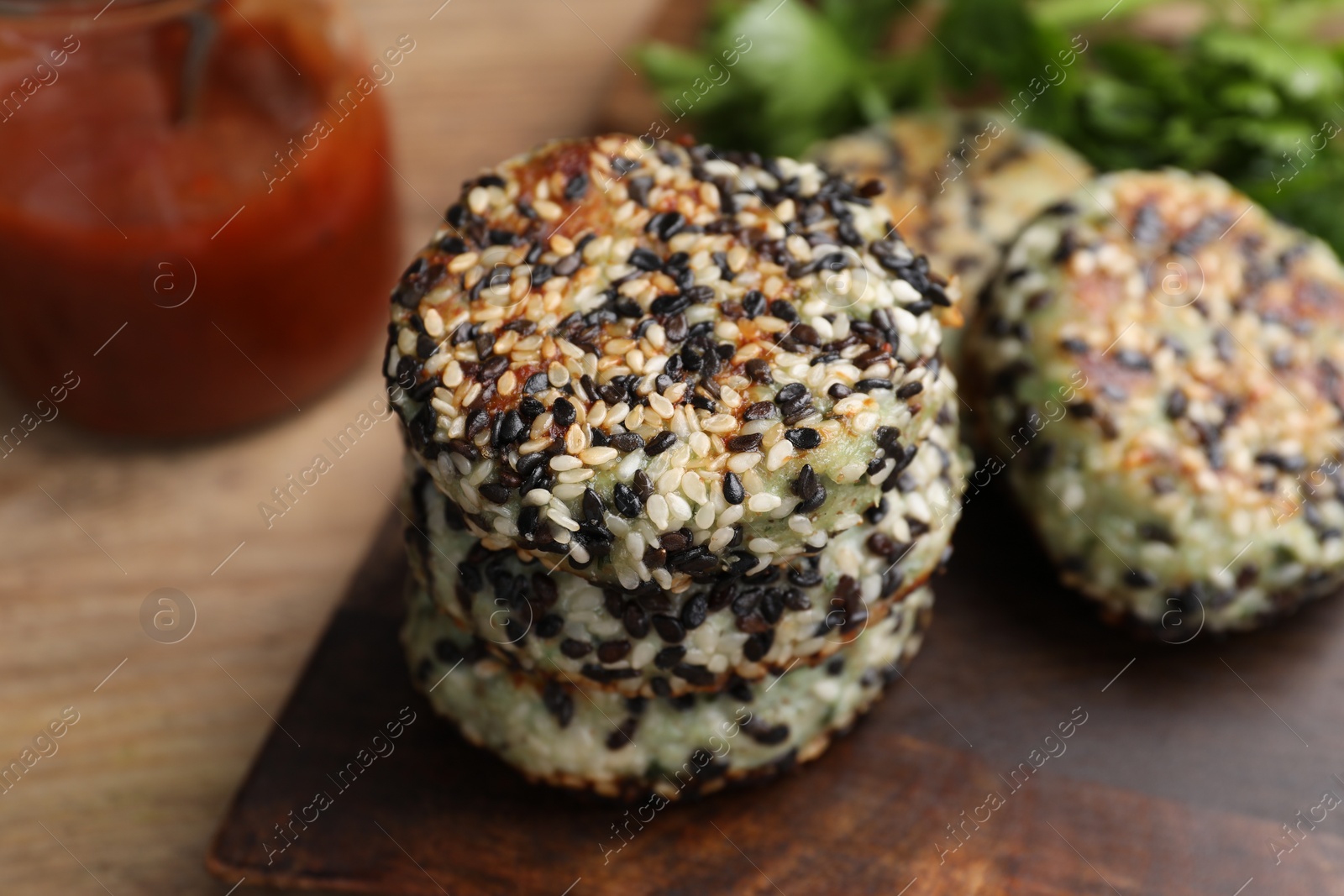 Photo of Delicious vegan cutlets with sesame on wooden table, closeup