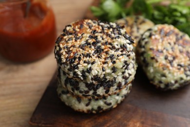 Photo of Delicious vegan cutlets with sesame on wooden table, closeup