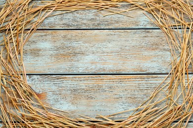 Photo of Frame of dried hay on light wooden background, flat lay. Space for text