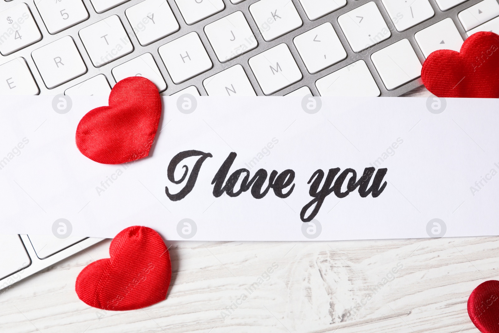 Photo of Card with text I Love You, red hearts and keyboard on white wooden background, flat lay