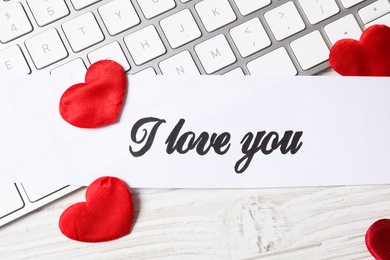 Card with text I Love You, red hearts and keyboard on white wooden background, flat lay