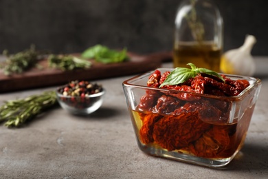 Photo of Bowl with sun dried tomatoes on gray table