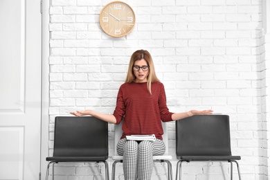 Photo of Young woman waiting for job interview, indoors