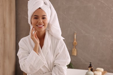 Beautiful African American woman in bathroom, space for text