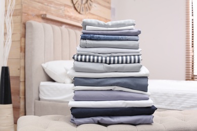 Photo of Stack of clean bed linens in bedroom