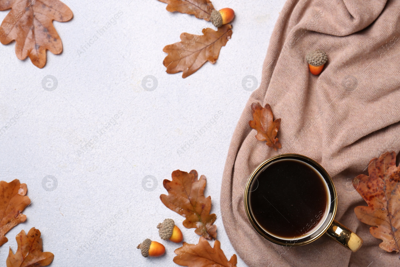 Photo of Flat lay composition with cup of hot drink and autumn leaves on light grey textured table. Space for text