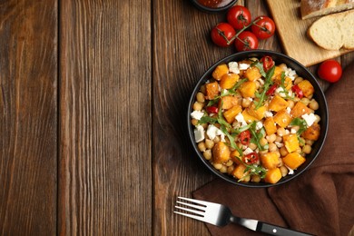 Photo of Delicious fresh chickpea salad served on wooden table, flat lay. Space for text