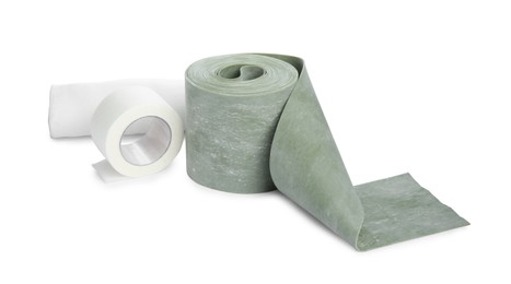 Photo of Medical bandage rolls and sticking plaster on white background