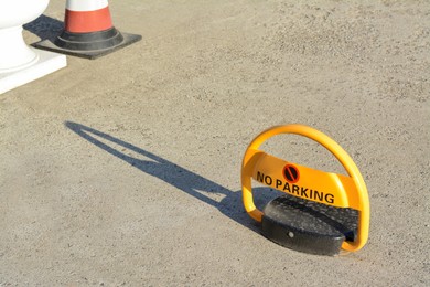 Photo of Parking barrier with No Stopping road sign on asphalt outdoors, space for text