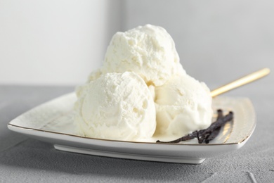 Plate with tasty vanilla ice cream on table