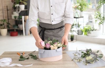 Photo of Male florist creating floral composition at workplace