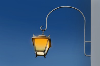 Image of Beautiful old fashioned street lamp lighting on wall of building