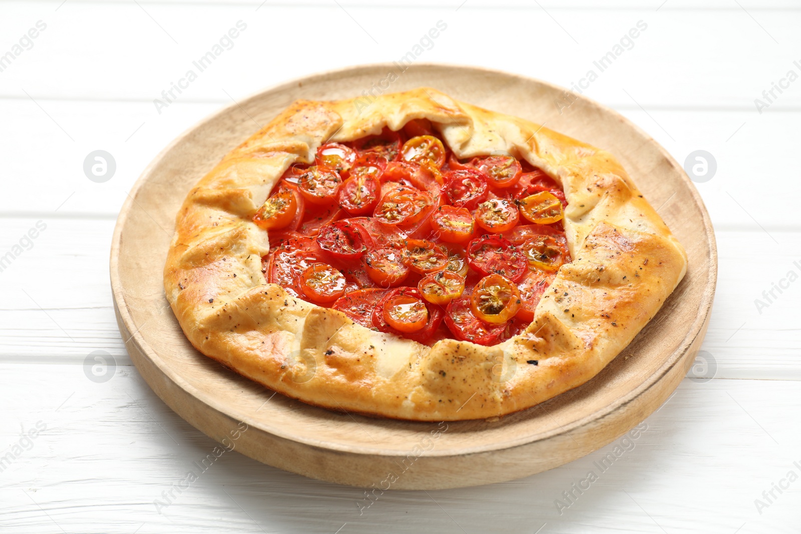 Photo of Tasty tomato galette (Caprese galette) on white wooden table, closeup