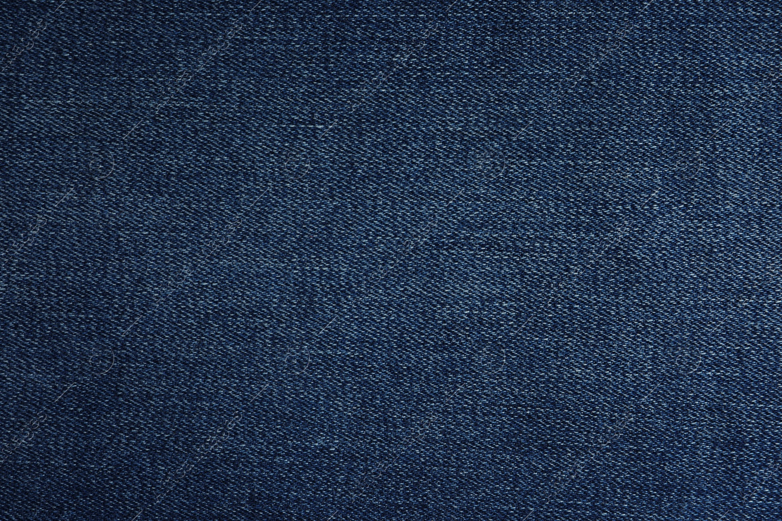 Photo of Texture of dark blue jeans as background, closeup