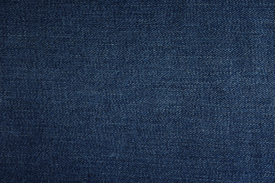 Photo of Texture of dark blue jeans as background, closeup