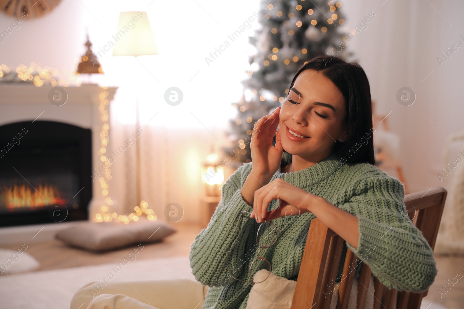 Photo of Young woman in armchair at home, space for text. Christmas celebration