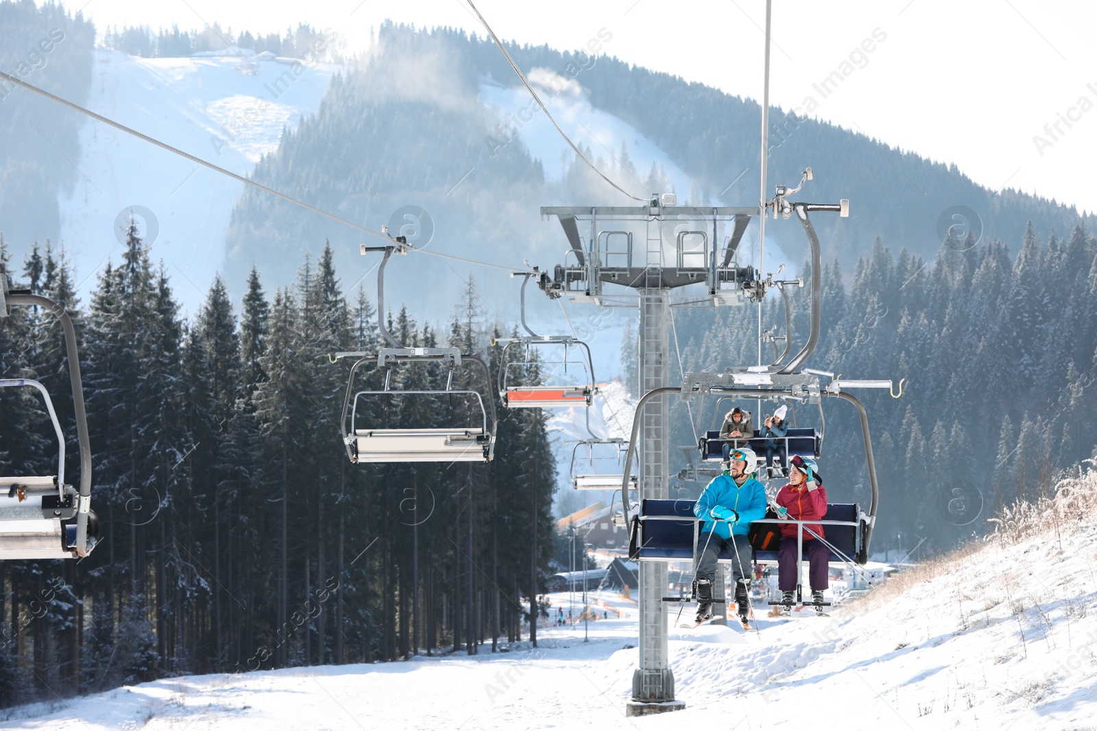 Photo of People using chairlift at mountain ski resort. Winter vacation