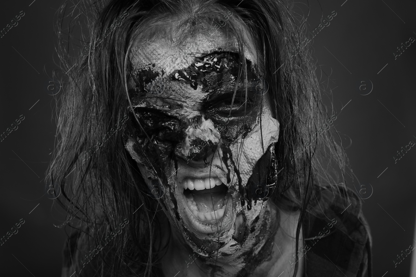 Photo of Scary zombie on dark background, black and white effect. Halloween monster