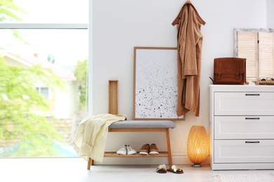 Modern hallway interior with shoe storage bench and chest of drawers. Space for text