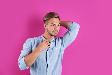 Young man with trendy hairstyle on color background