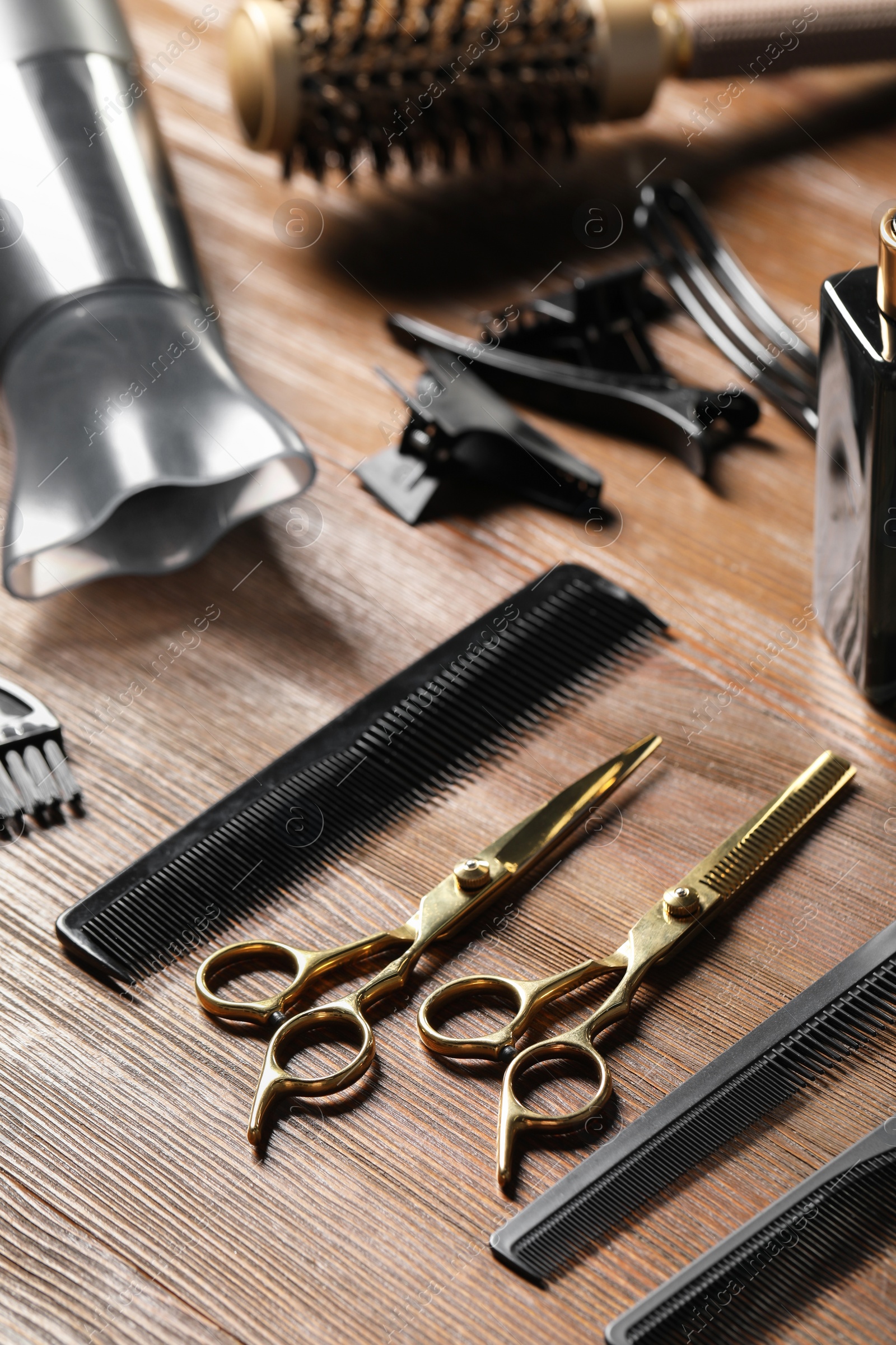 Photo of Hairdresser tools. Different scissors and combs on wooden table, closeup