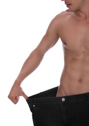 Shirtless man with slim body wearing big jeans isolated on white, closeup