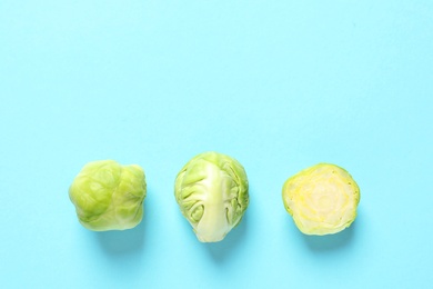 Photo of Fresh Brussels sprouts on color background, flat lay. Space for text