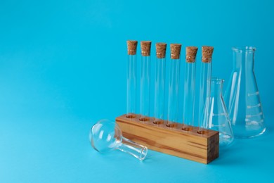 Photo of Different laboratory glassware on light blue background, space for text