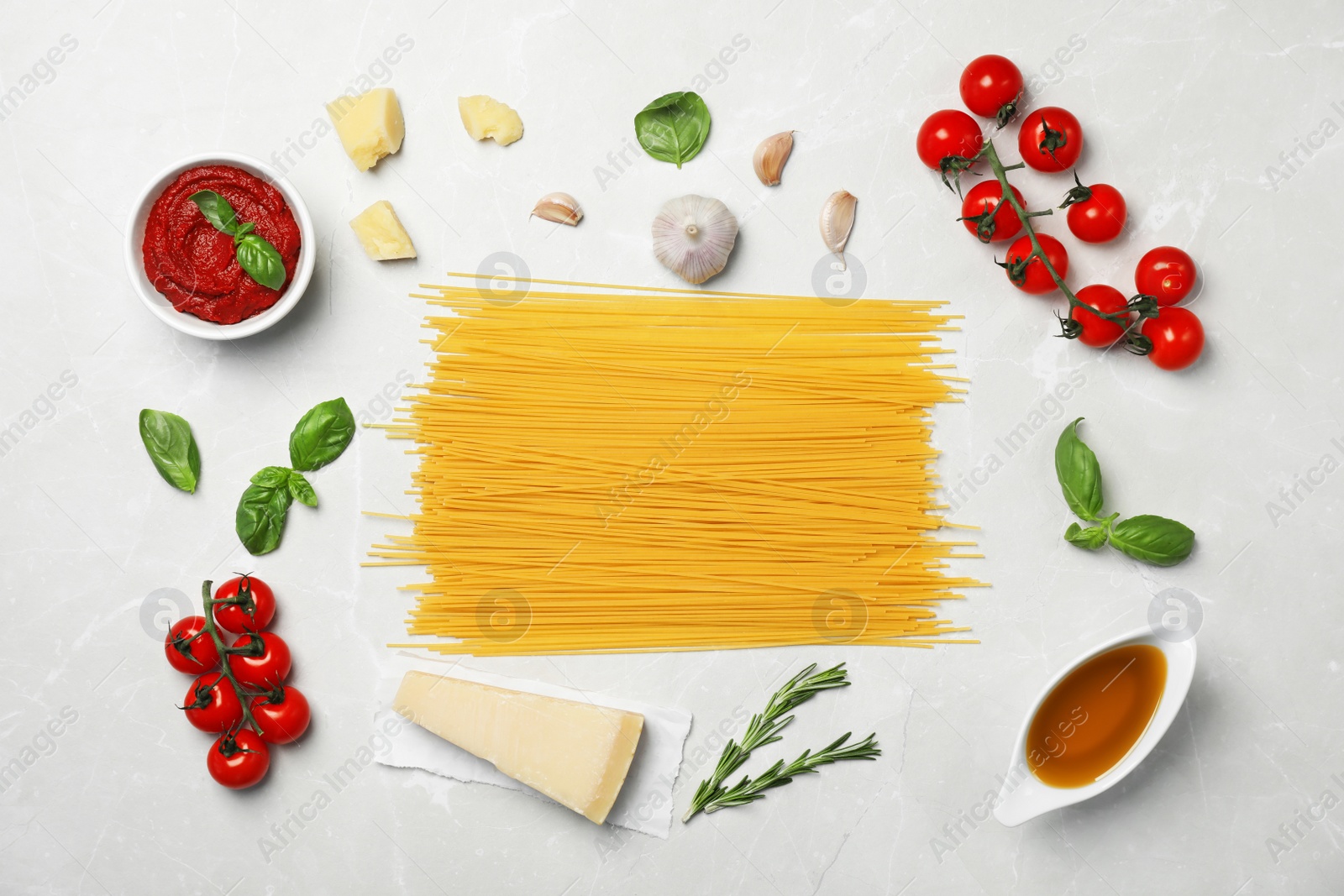 Photo of Beautiful composition with raw pasta and ingredients for sauce on table, top view