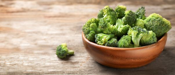 Image of Fresh green broccoli on wooden table, space for text. Banner design 