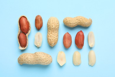 Fresh peanuts on light blue background, flat lay