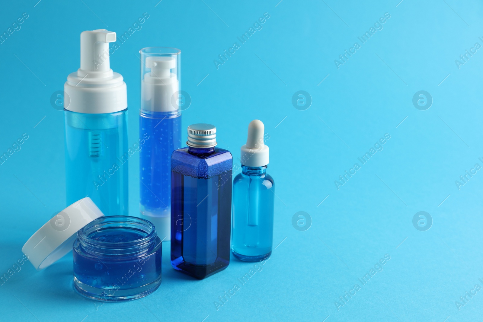 Photo of Set of luxury cosmetic products on light blue background. Space for text