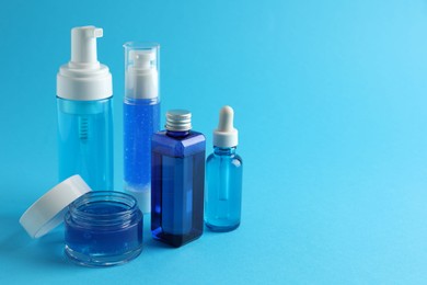 Set of luxury cosmetic products on light blue background. Space for text