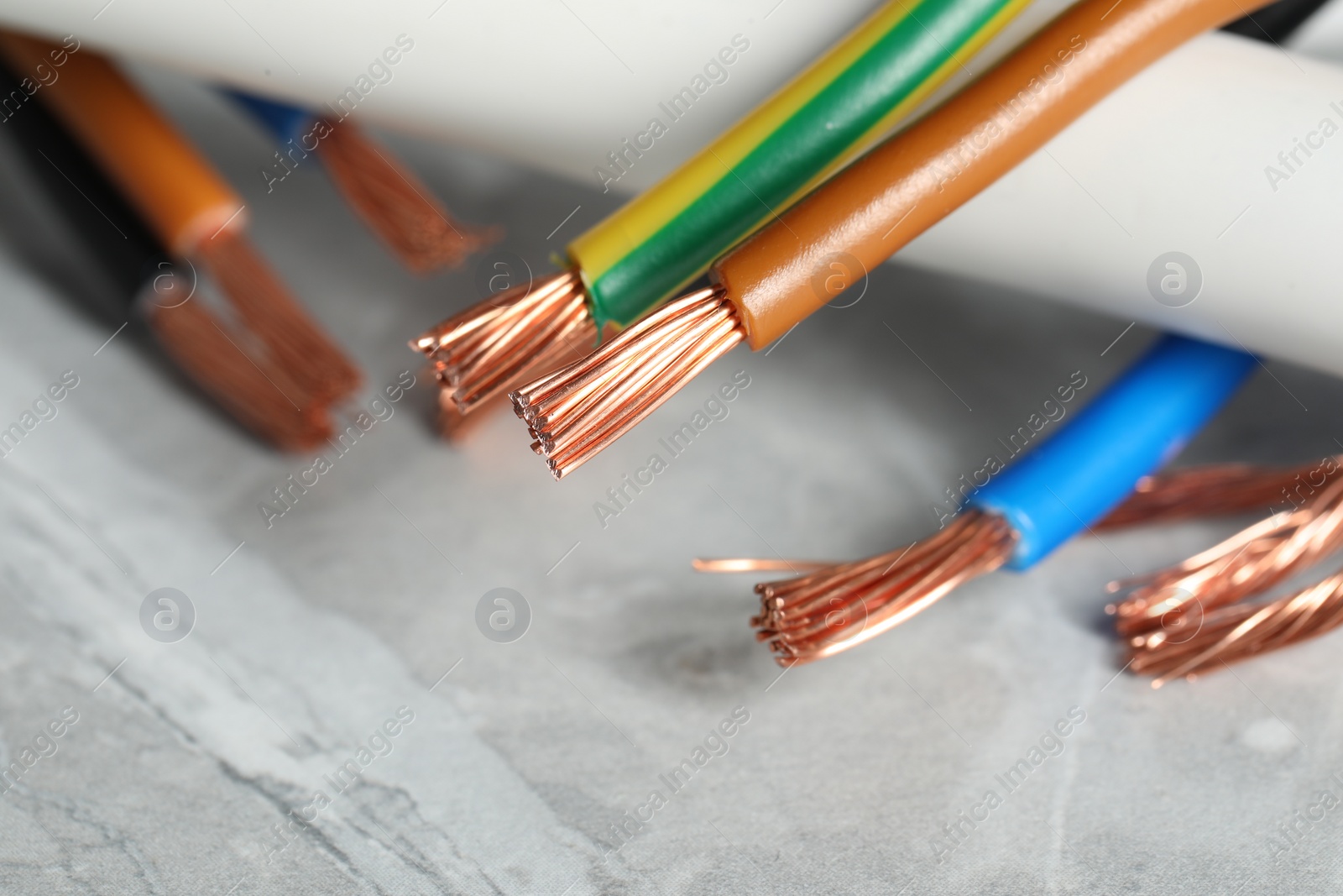 Photo of Colorful electrical wires on gray textured surface, closeup