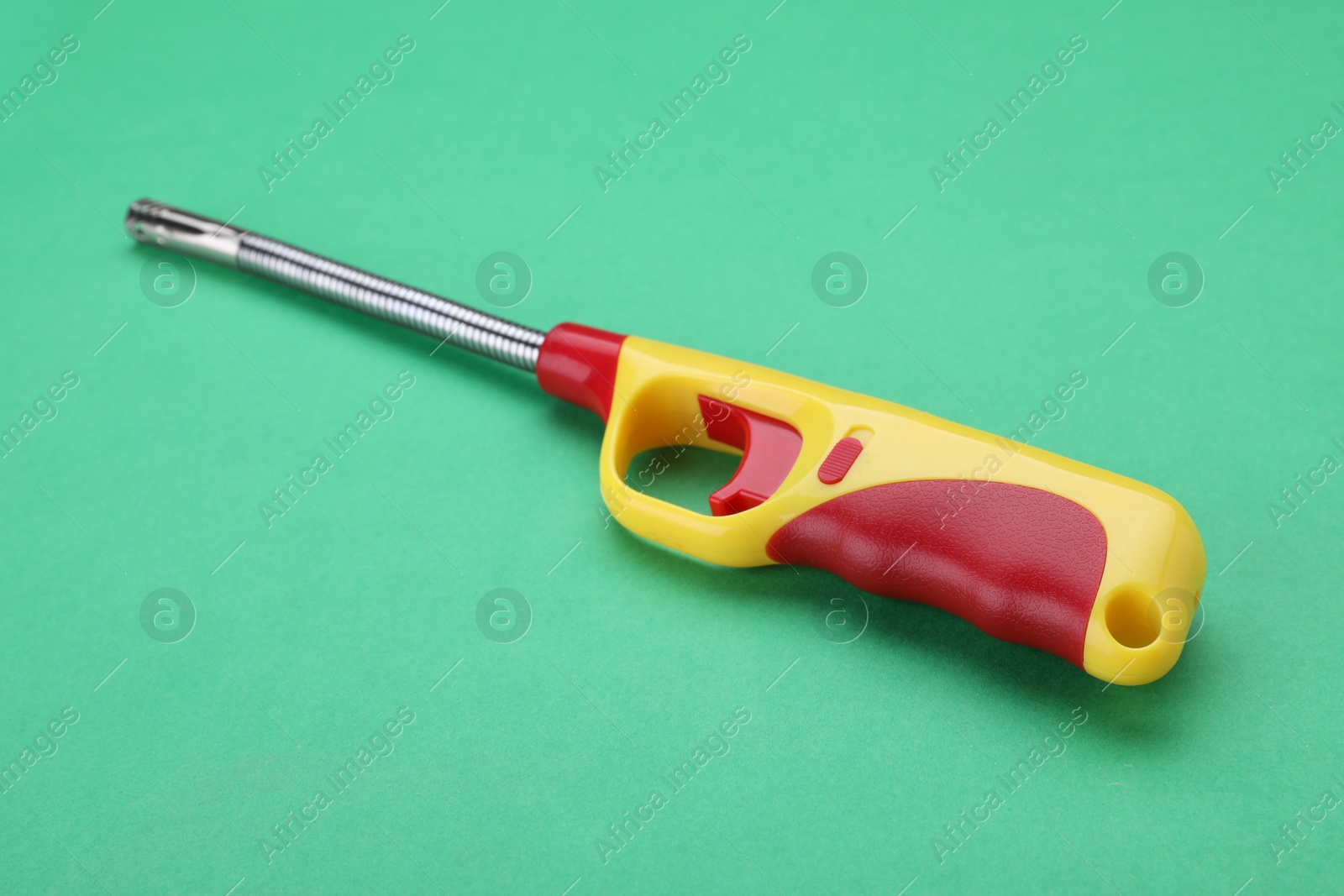 Photo of One bright gas lighter on green background