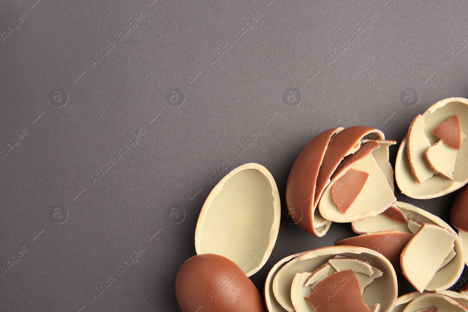 Photo of Sveti Vlas, Bulgaria - July 3, 2023: Broken halves of Kinder Surprise Eggs on grey background, flat lay. Space for text