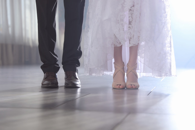 Photo of Newlywed couple in festive hall, closeup of legs