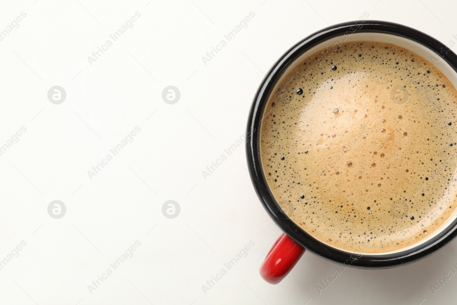Photo of Cup of aromatic coffee on white table, top view. Space for text