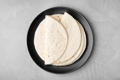 Photo of Plate with corn tortillas on grey background, top view. Unleavened bread