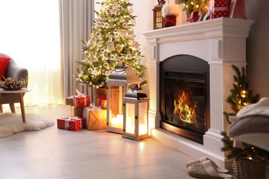 Photo of Stylish living room interior with beautiful fireplace, Christmas tree and other decorations