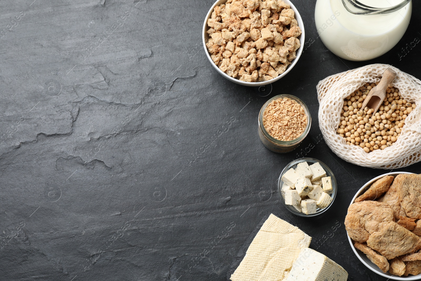 Photo of Different organic soy products on black table, flat lay. Space for text