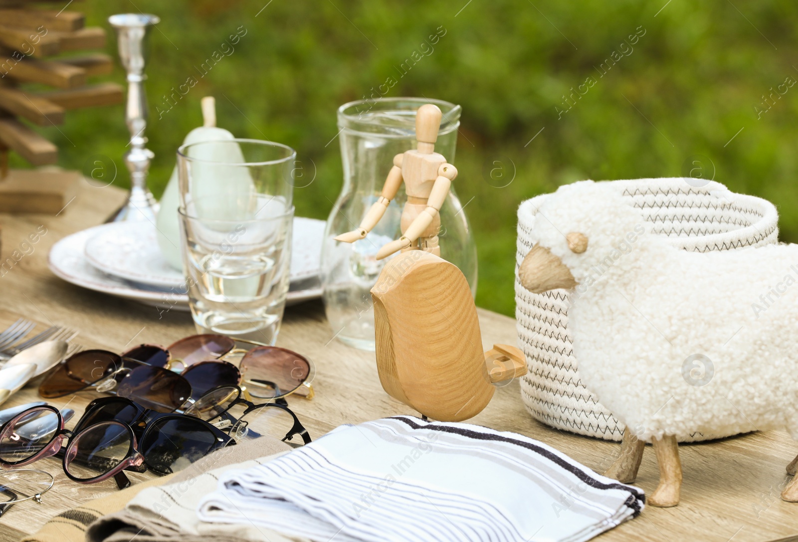 Photo of Many different decorative items on wooden table outdoors. Garage sale