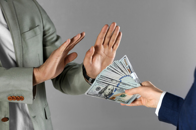 Photo of Man refusing to take bribe on grey background, closeup of hands