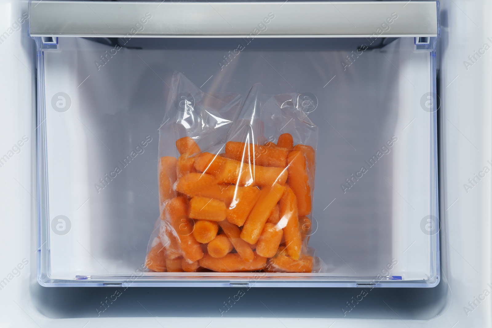 Photo of Pack of carrot on drawer of refrigerator